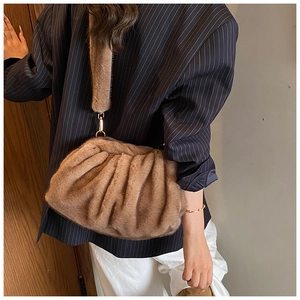 Detail of a brown plush crossbody bag featuring soft faux fur texture and gold hardware