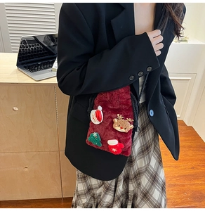 Detail of red plush Christmas bucket bag with festive Santa and reindeer embroidery