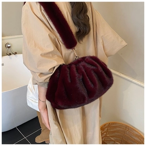 Macro detail of wine red faux fur crossbody bag featuring plush texture and gold hardware