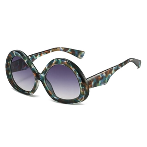 Oversized round sunglasses featuring colorful tortoiseshell frames and gradient purple lenses