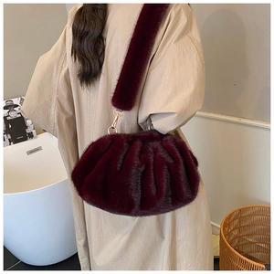 Close-up of plush dark wine red faux fur crossbody bag with textured cloud design folds