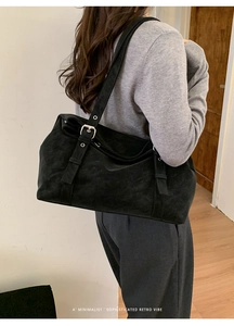 Détail du grand sac cabas noir en daim avec boucles argentées et design minimaliste