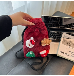 Detail of red plush Christmas drawstring bag with 3D Santa and Reindeer embroidery