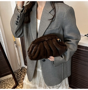 Détail d'un sac nuage en peluche marron foncé avec bandoulière chaîne sur le modèle