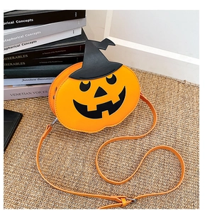 Detail of orange pumpkin crossbody bag with a black wizard hat and adjustable strap