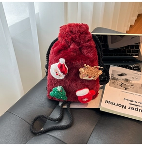 Close-up of plush wine red Christmas drawstring handbag with festive 3D embroidery details