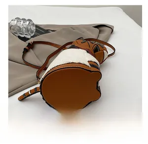 Close-up of brown textured leather and white faux fur patchwork on bucket bag bottom
