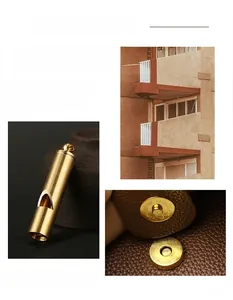 Detail of brass-toned whistle pendant and magnetic snap on litchi grain leather bag