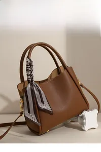 Detailed macro view of brown lychee grain leather handbag with decorative striped silk scarf