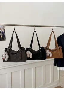 Détail des boucles argentées et du charm lapin en peluche sur les sacs cabas de luxe