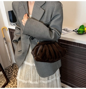 Détail de sac coquillage chic en fausse fourrure marron avec chaîne argentée délicate