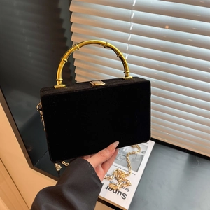 Détail du sac bandoulière en velours noir avec poignée dorée en forme de bambou