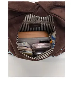 Deep brown suede handbag showing large capacity interior with striped lining and magnetic closure