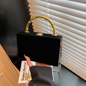 Détail du sac bandoulière en velours noir avec poignée en bambou doré et chaîne
