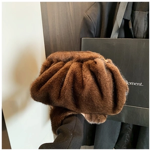 Macro view of dark brown faux fur cloud bag with soft pleated texture and gold zipper