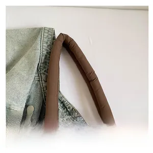 Close-up of the soft padded handle on the brown quilted tote bag showing sewing details