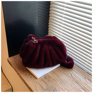 Detail of burgundy faux mink fur handbag with cloud pleats and gold metal clasp
