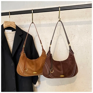 Close-up of minimalist suede crescent hobo bag with contrast stitching and gold hardware