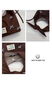 Detail view of coffee brown suede handbag with blue ribbon bow and striped lining