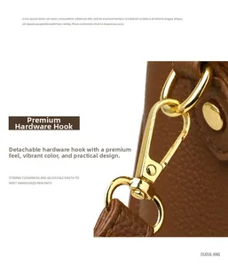 Detail of dark brown pebble leather bag featuring a detachable gold metal hardware hook