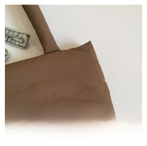 Detailed close-up of premium quilted nylon fabric on a brown large capacity tote bag