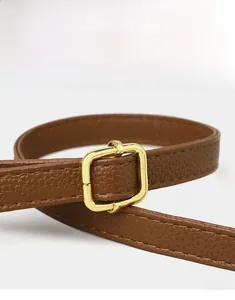 Detail of brown litchi leather strap with adjustable gold square buckle and stitching
