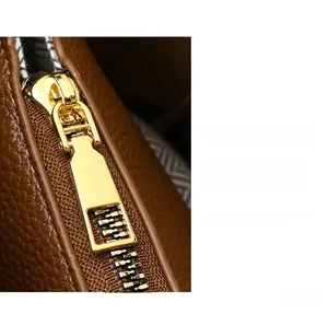 Macro detail of high-quality brown lychee leather and premium gold metal zipper puller