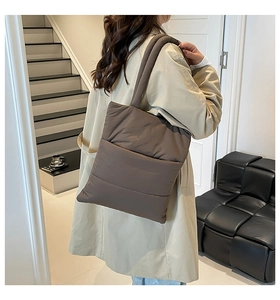 Detail of coffee brown quilted puffer tote bag in light nylon material for winter