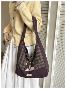 Detail of purple canvas tote bag featuring houndstooth pattern and cat illustration