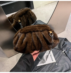 Détail des plis en fausse fourrure marron d'un sac coquillage avec chaîne argentée