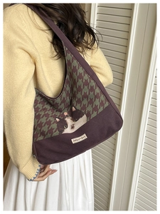 Detail of canvas tote bag featuring upper houndstooth pattern and black cat graphic print