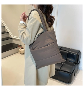 Close-up of padded dark brown quilted tote bag showing plush texture on shoulder