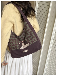 Detail of purple canvas tote bag featuring houndstooth pattern and a cute cat illustration