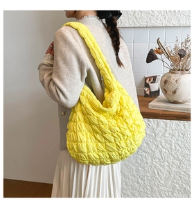 Detail einer leuchtend gelben gesteppten Puffer-Einkaufstasche mit Blasenstruktur und Zipper