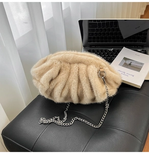 Détail du sac nuage en fausse fourrure beige avec chaîne argentée sur pouf en cuir