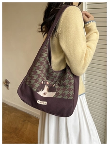 Detail of canvas tote bag with cat print and houndstooth pattern shown on model