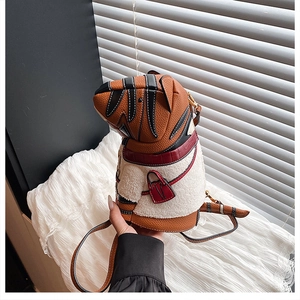 Detail of unique tiger print bucket bag with plush sheepskin texture and red trim accents