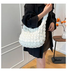 Detalle del bolso nube acolchado blanco con textura plisada suave y correa gruesa acolchada