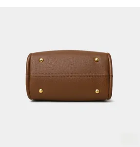 Detailed base view of brown lychee grain leather handbag with four gold protective metal feet