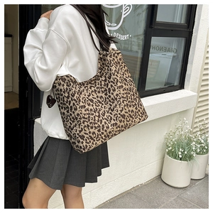 Détail du grand sac cabas léopard avec pendentif en forme de cœur et bandoulière large