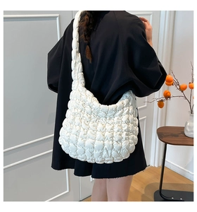 Detail der weißen gesteppten Cloud-Tasche mit weicher Textur und großer Mondform