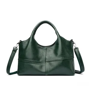Macro detail of dark green faux leather stitching and glossy texture on the handbag