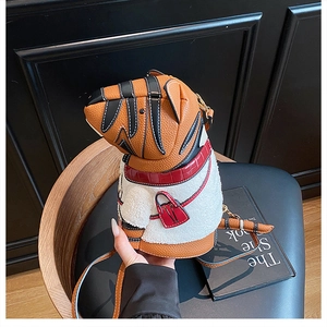 Detail of creative tiger-shaped bucket bag with brown pebble leather and white faux fur trim