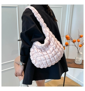 Detalle del bolso acolchado rosa tipo nube llevado por modelo con camisa negra