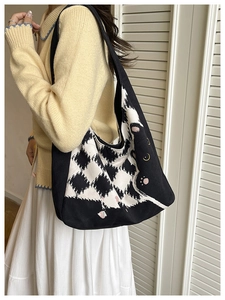 Detail of canvas tote bag featuring a black cat design and checkerboard pattern