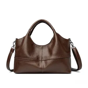 Detail of dark brown tote bag showing cross stitching and soft faux leather texture