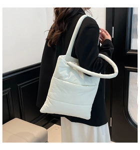 Modern white quilted puffer tote bag shown on model with comfortable padded shoulder straps