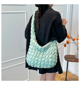 Detail of mint green quilted cloud bag featuring soft padded texture and ruched nylon finish