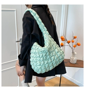 Detalle del bolso nube verde menta que muestra la textura acolchada y la correa ancha