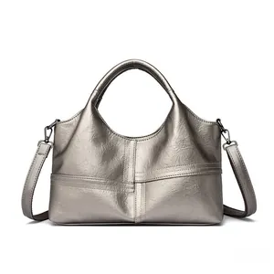 Detail of metallic silver tote bag featuring pebbled texture and detachable shoulder strap